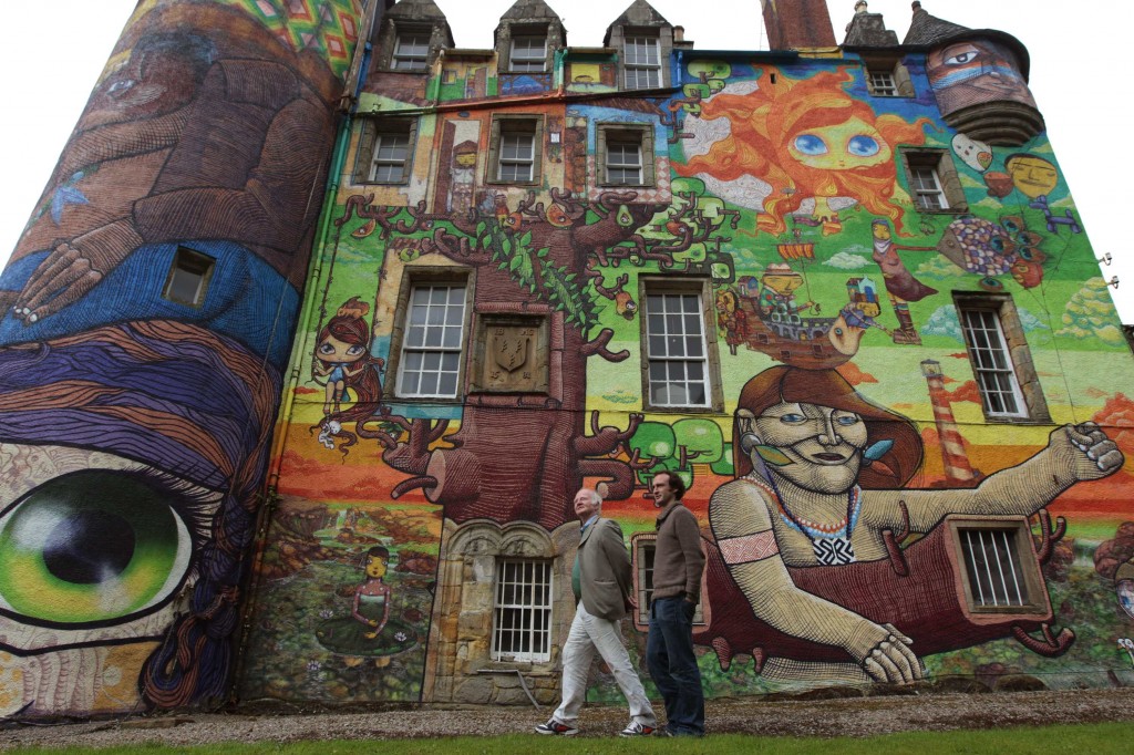 The Earl of Glasgow, Patrick Boyle, and his son David, pose for photographers next to graffiti paintings by Brazilian artists on the walls of Kelburn Castle near Largs, Scotland